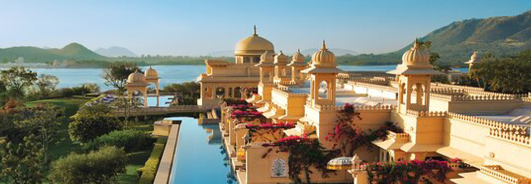 Luxury lakeside resort with traditional Rajasthani architecture, scenic water views and surrounding hills in Udaipur, Rajasthan.