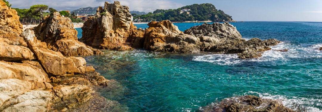 Rocky Mediterranean coastline in Costa Brava, Spain, featuring turquoise-blue waters, rugged cliffs and scenic coastal landscapes.